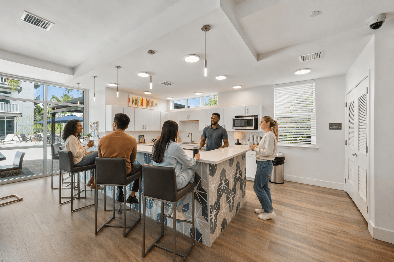 Four people are sitting at a bar with a woman standing behind it.
